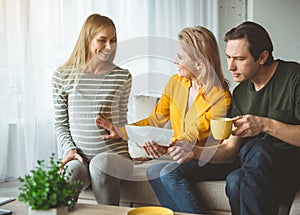 Cheerful married couple talking with surrogate expectant mother