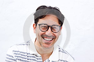 Cheerful mature man with glasses smiling against white background