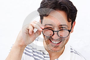 Cheerful mature man holding glasses and winking