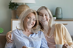 Cheerful mature mother and happy joyful young adult daughter girl