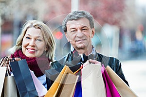 Cheerful mature spouses with shopping bags