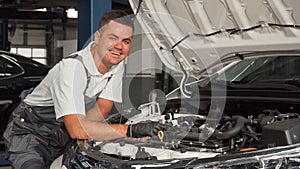 Cheerful mechanic enjoying working at the garage