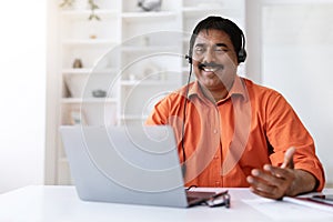 Cheerful middle aged eastern man working from home office