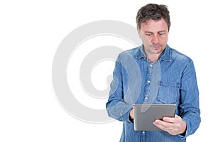 Cheerful middle aged man using tablet computer with side copy space