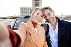 Cheerful middle-aged marriage taking selfie looking at camera. Smiling and happy couple having fun