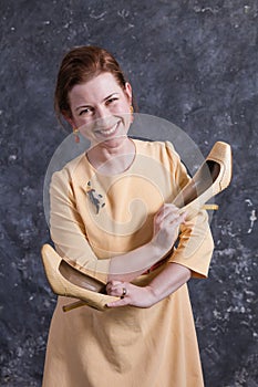 Cheerful middle aged woman dressed in beige dress studio portrait.
