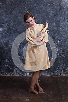 Cheerful middle aged woman dressed in beige dress studio portrait.