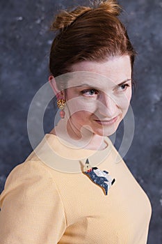 Cheerful middle aged woman dressed in beige dress studio portrait.