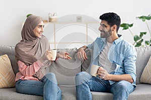 Cheerful Middle Eastern Spouses Drinking Coffee And Talking At Home