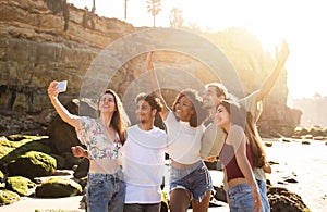 Cheerful millennial international people students enjoy summer holidays, have fun, taking selfie on smartphone