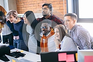 Cheerful mixed race office workers are celebrating successful contract