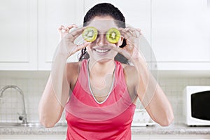 Cheerful model with pieces of kiwi fruit