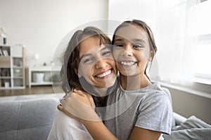 Cheerful mom and happy tween daughter kid hugging with love