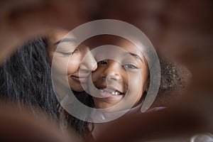 Cheerful mom and kid with tooth gap making hand heart