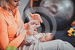 Cheerful mom is playing with her baby while waiting for a doctor