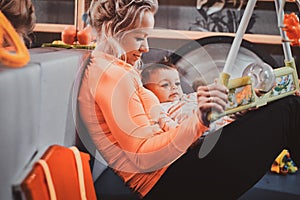 Cheerful mom is playing with her baby while waiting for a doctor