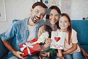 Cheerful mom posing with her daughter and husband