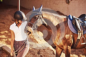 Cheerful mood. Horsewoman in uniform and black protective helmet with her horse