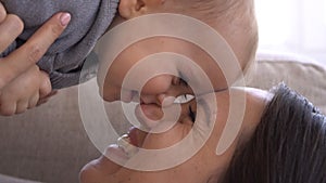 Cheerful mother and baby daughter lying face to face