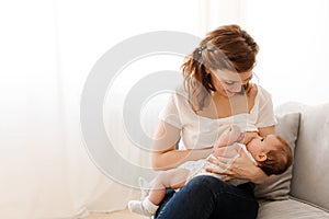 Cheerful mother breastfeeding cute baby