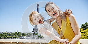 Cheerful mother and child hugging while in Paris, France