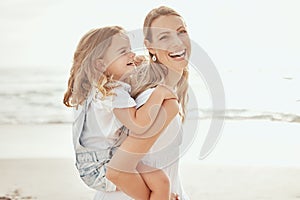 Cheerful mother and daughter having fun at beach. Young mother giving her daughter piggyback ride at beach. Precious