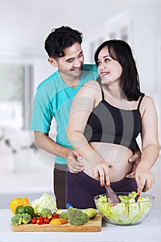 Cheerful mother and her husband in kitchen