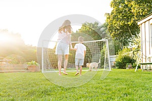 Cheerful mother and son playing with dog, throwing a ball and have fun together. Happy family playing with tennis ball