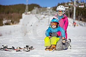 Cheerful mother and son resting on ski slope
