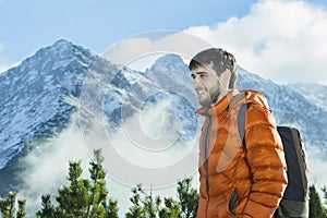 Cheerful mountain guide having rest at astonishing winter rocky landscape background photo