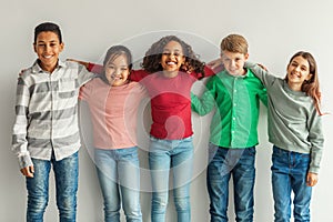 Cheerful Multiethnic Children Hugging Posing Smiling To Camera Indoors