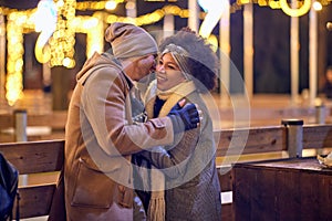 Cheerful multiethnic couple enjoying winter night