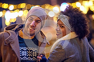 Cheerful multiethnic couple exploring the city; Holiday joy concept
