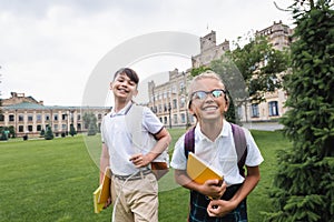 Cheerful multiethnic schoolkids with copy books