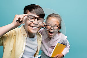 Cheerful multiethnic schoolkids in eyeglasses holding