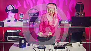 Cheerful musician working as dj in night club mixing sounds