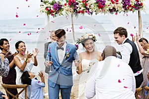 Cheerful newlyweds at beach wedding ceremnoy