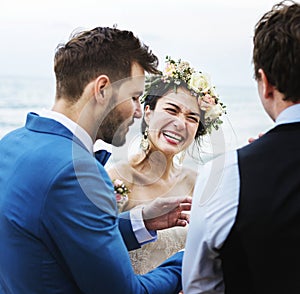 Cheerful newlyweds at beach wedding ceremony