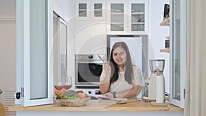 Cheerful obese asian woman preparing ingredient for making healthy salad in home kitchen