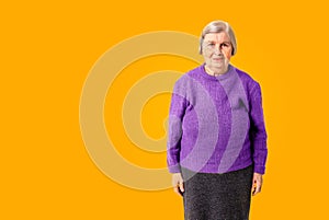 Cheerful octogenarian woman on yellow background with copy space