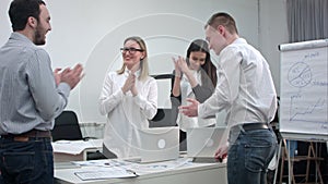 Cheerful office people applauding and shaking their hands after great work