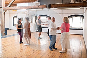 Cheerful old Caucasian couples dancing and laughing in studio