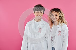 cheerful oncologists with ribbons on white