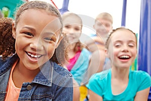 Cheerful optimism. A multi-ethnic group of happy children playing on a jungle gym in a play park.