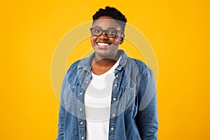 Cheerful Overweight African American Lady Posing Over Yellow Background photo