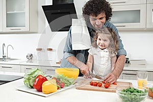 Cheerful parent teaching his child to cook