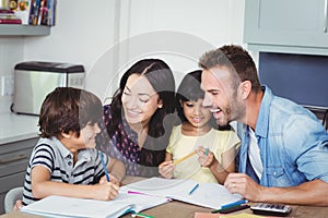 Cheerful parents assisting children in homework