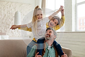 Cheerful Parents And Daughter Having Fun Bonding Playing At Home