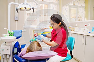 Cheerful pediatric dentist with a patient. training in proper brushing