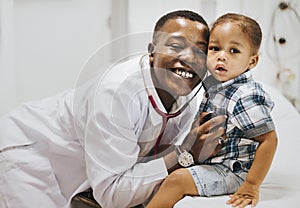 Cheerful pediatrician doing a medical checkup of a young boy photo